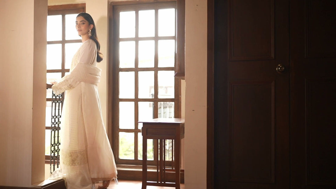 A woman in ivory by a tall window, from the Vasl film
