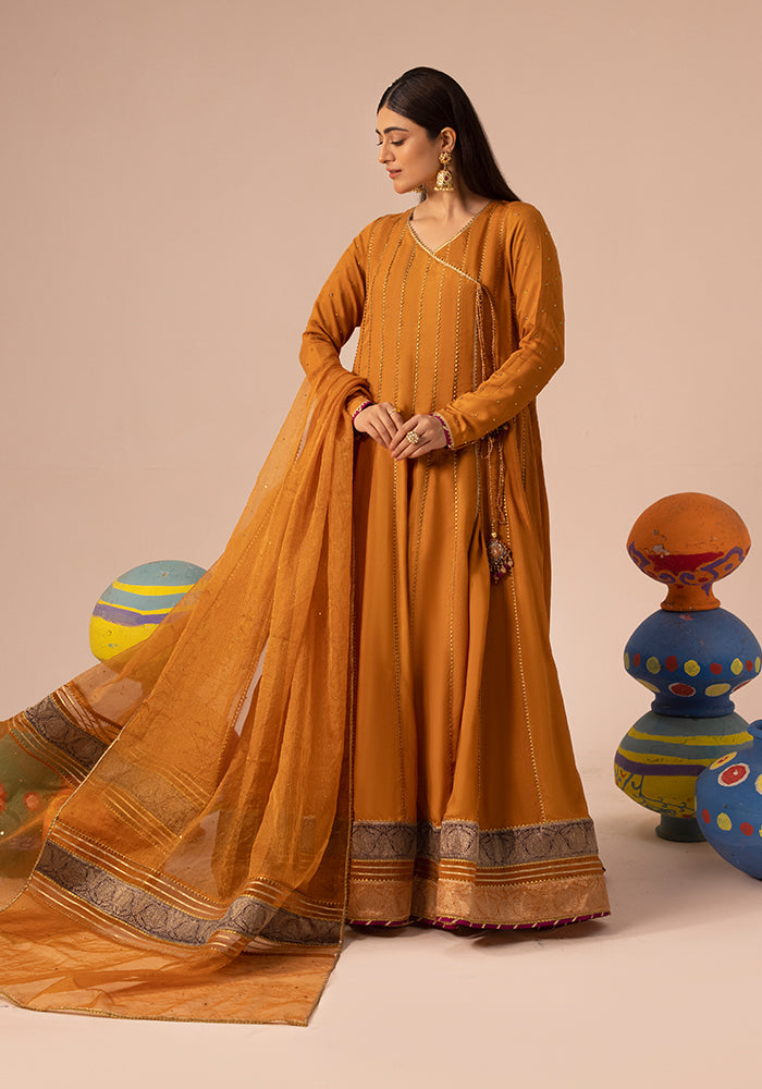 A mustard Zeest anarkali among painted clay pots